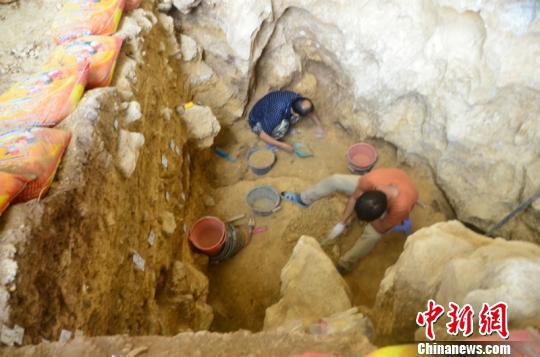 图为工作人员在清理遗址 钟欣 摄
