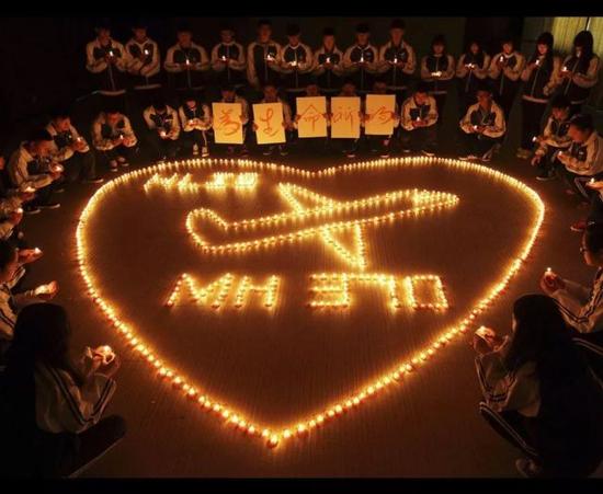 资料图片:中国学生点燃蜡烛为MH370乘客祈福。