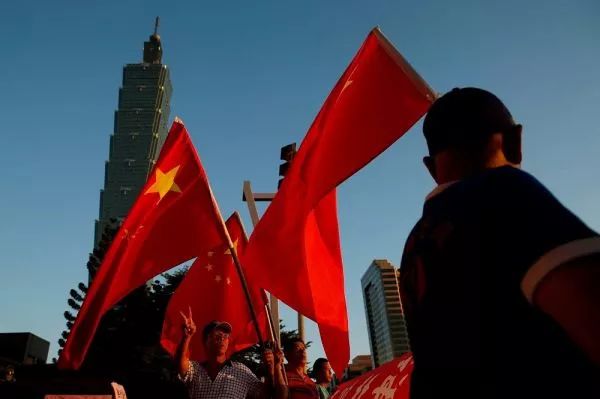 ▲台北街头,台湾民众手持五星红旗。(图片来源:台媒)