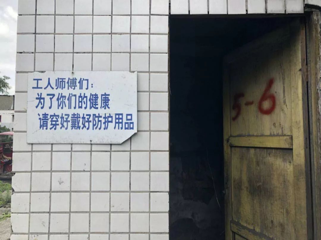 矿区墙上写着提醒工人戴好防护用品的标语。 新京报记者 王翀鹏程 摄