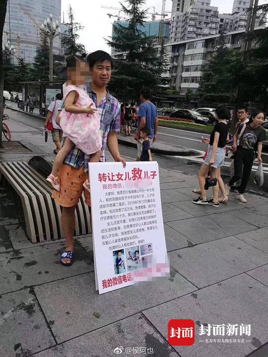 梁育佳站在街头,怀里抱着女儿,面前放着一块牌子:“转让女儿救儿子。”